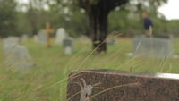 A-man-walks-in-the-background-of-a-cemetery