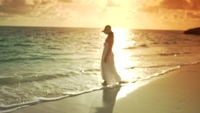 Vrouw in witte jurk lopen op het strand
