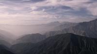 Time-lapse-of-clouds-moving-from-left-to-right-on-mountain-range-with-blue-sky-in-background-in-4k