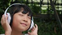 Liten flicka lyssnar på musik från hörlurar och bra känsla