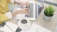 Woman working laptop on desk in living room at home.