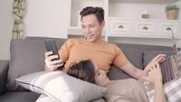 Asian couple using devices at home