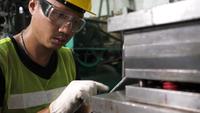 Ingenieur, der ein Tablet verwendet und eine Maschine überprüft