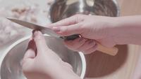 Slow motion close up on hands peeling off a garlic