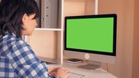 Mulher morena olhando para o monitor do computador no trabalho