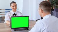 Coworkers Sitting at The Desk in Front of Each Other at Workplace