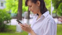 Caucasian Woman bavardant en ligne dans le parc