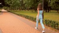 Vue arrière d&#39;une femme marchant sur un parc de la ville