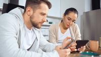 Homme et femme assis dans leur cuisine le matin