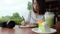Voyageur asiatique écrit dans un cahier.