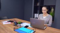 Femme d&#39;affaires travaillant sur un ordinateur portable dans un bureau moderne
