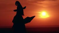 Fille silhouette en robe de soirée et chapeau de sorcière jette un sort vue du lever du soleil