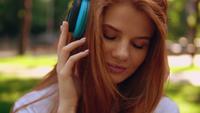 Tête rousse femelle écoutant une chanson à l&#39;extérieur