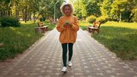 Jeune femme, marche, dans parc, utilisation mobile