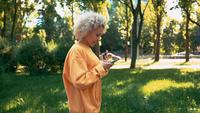 Vue de côté femme blonde défile flux de nouvelles à l&#39;extérieur
