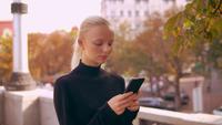 Portrait blonde utilise le mobile en ville