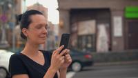 Brunette à l&#39;aide d&#39;un mobile en ville
