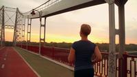 Une femme de jogging méconnaissable court sur le pont