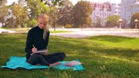 Écriture blonde dans un ordinateur portable à l&#39;extérieur