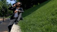 Homme parlant au téléphone assis sur l&#39;herbe