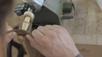 Mann, der ein hölzernes Teil mit Leder poliert