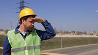 Worker in A Helmet Stands on The Bridge