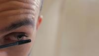 Man Paints Eyelashes with Mascara