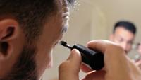 Man Applying Makeup in Front of a Mirror