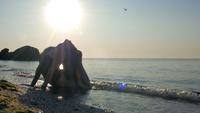 Girl in Bodysuit Doing Yoga by The Sea